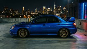 藍色Subaru WRX STI停泊在屋頂，夜晚城市燈光