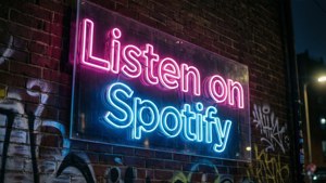 夜間磚牆上帶有塗鴉的霓虹Spotify標誌