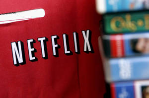 紅色Netflix袋旁邊有一疊VHS錄影帶。 — Netflix GIF 壁紙