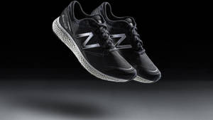 帶有銀色標誌的黑色 New Balance 運動鞋在攝影棚燈光下漂浮。