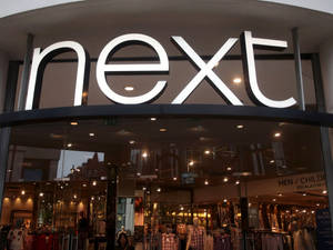 Next服裝店正面，配有玻璃窗和發光招牌。