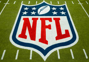 NFL標誌繪製在綠色足球場草地上，帶有白色碼線。