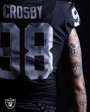黑色Raiders足球球衣背面，號碼98和名字Crosby，顯示有紋身的手臂。