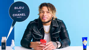 身穿皮褸的男子手持 Chanel 產品，背景有品牌標誌。
