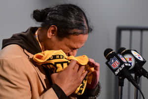 男子在NFL記者會上將臉埋在鋼人隊毛巾中哭泣。