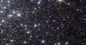 深空中佈滿明亮星星的密集星場，帶有鏡頭光暈。 — 太空 壁紙