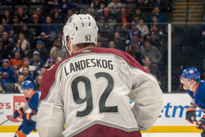 冰球運動員Landeskog 92號在比賽中站在冰上，背景有觀眾。 — 運動 壁紙