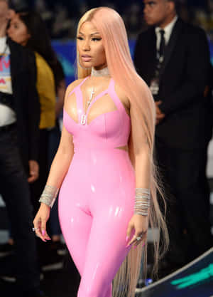 Nicki Minaj 在紅地毯活動中穿著閃亮粉紅色乳膠連身衣，佩戴銀色珠寶。 — 妮琪·米娜 壁紙