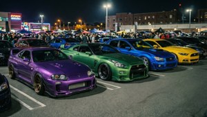 夜間車展，展示紫色、綠色、藍色和黃色的閃亮改裝跑車。
