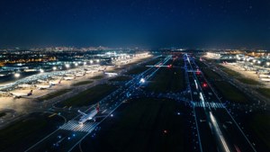 夜間機場，跑道閃爍，停機坪上停著飛機，星空璀璨