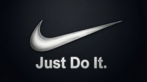 銀色Nike swoosh標誌，帶有'Just Do It.'文字，深色背景
