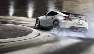 銀色日產370Z Nismo在隧道中飄移，伴有煙霧和動態模糊。