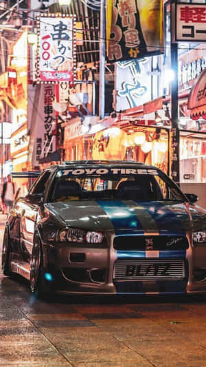 改裝銀色跑車帶藍色條紋，夜晚停在潮濕霓虹燈日本街道上。 — 汽車 壁紙