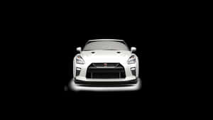 白色日產GT-R跑車在黑色背景下照亮。