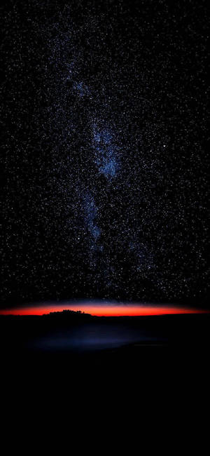 繁星點點的夜空，紅色地平線在黑暗的大地輪廓上方