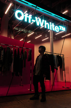 站在 Off-White 商店前，有霓虹燈和衣架。