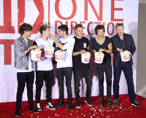 One Direction 樂隊成員在活動的紅地毯上手持爆谷桶。 — 5:4 壁紙