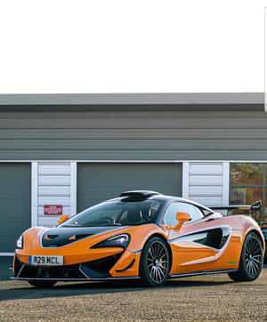 橙色McLaren跑車停在工業建築前。 — Pixel Fold 壁紙