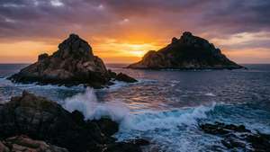 夕陽下的岩石海岸，海浪拍打，天空壯麗