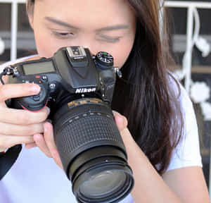 年輕女性手持Nikon DSLR相機進行攝影