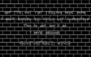 黑色磚牆上的白色塗鴉文字寫著「Comfortably numb」及其他文字