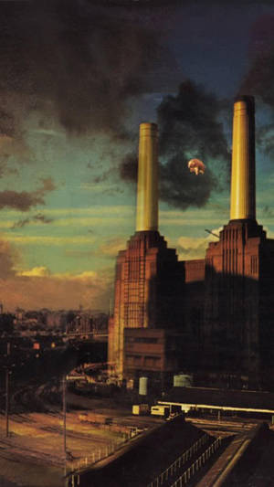 黃昏時分嘅Battersea Power Station，有一隻漂浮嘅豬同煙囪升起嘅煙。