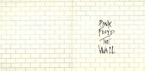在奶油色磚牆上以黑色墨水寫成的Pink Floyd The Wall。
