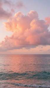 粉紅色和橙色雲彩在日落地平線的平靜海面上反射。