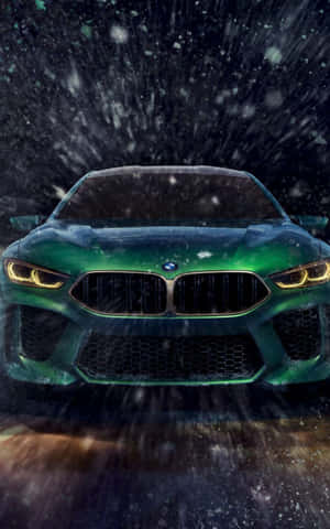 綠色BMW M8在夜間雪中疾馳，車頭燈閃爍。
