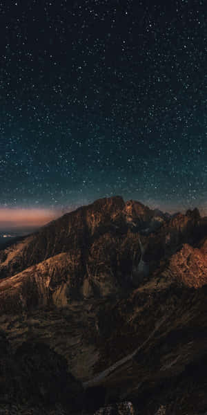 繁星點點的夜空在崎嶇的山峰之上，發光的地平線。