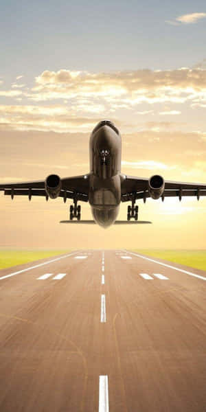 飛機在金色夕陽下接近跑道。 — 18:9 壁紙