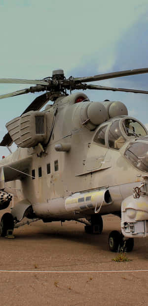 軍用直升機停泊在塵土飛揚的停機坪上，天空多雲 — 直升機 壁紙