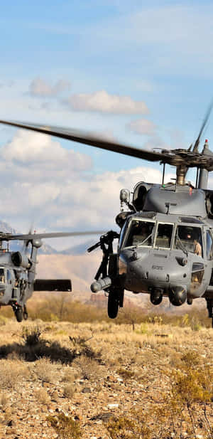 兩架軍用直升機盤旋於沙漠之上，背景有山脈。 — 直升機 壁紙