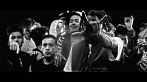 一張音樂表演中人群的黑白照片，中央人物正在做手勢。