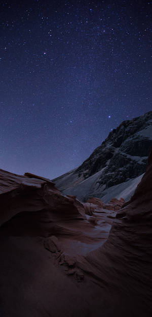 星空下的雪覆蓋山峽谷，帶有紅色岩層 — 夜晚 GIF 壁紙