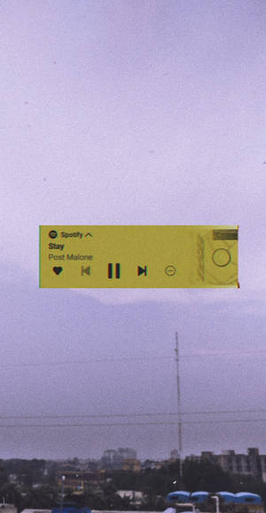 一個漂浮的Spotify音樂播放器，位於黃昏的城市天際線之上。