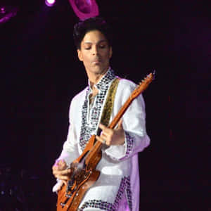 Prince 在紫色燈光下身穿白色服裝在舞台上彈結他。 — 王子 壁紙