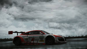 暴風雨天空下，紅白賽車在潮濕賽道上疾馳。 — Audi R8 GIF 壁紙