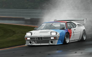 一架BMW M1 Procar在濕滑賽道上行駛，輪胎噴出水花。