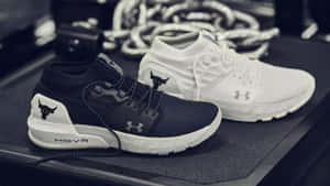 黑色和白色的Under Armour HOVR運動鞋放在健身墊上，背景有重量。 — 卡通鞋 壁紙