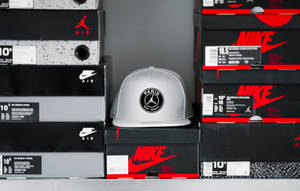 銀色帽子帶有PSG標誌在Nike Air Jordan鞋盒上。