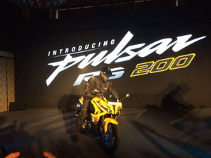 摩托車發布活動， featuring 一名騎手在黃色Pulsar RS 200單車上。