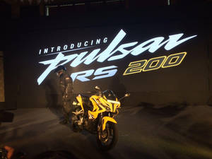 產品發佈活動中，黃色Pulsar RS 200電單車與騎手。 — 機車 壁紙