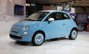 淺藍色Fiat 500在車展上展示，地板反光。 — Steam Deck OLED 壁紙