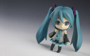 Q版初音未來公仔，藍綠色雙馬尾和藍色眼睛，灰色背景。 — 轟爆出久 壁紙
