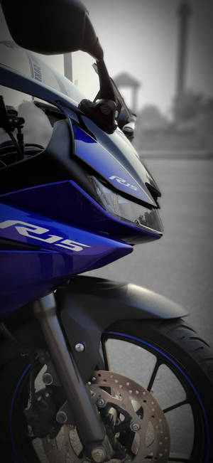藍色Yamaha R15電單車特寫，背景模糊的城市。