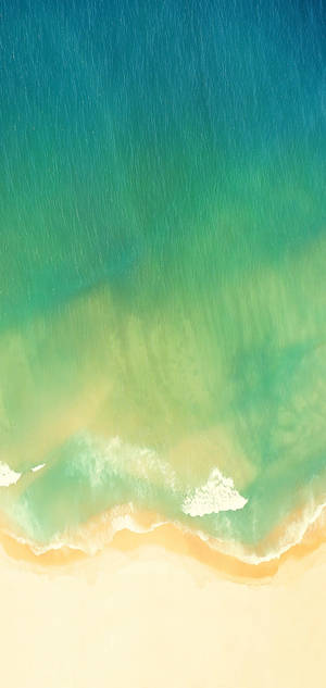 碧綠的海浪從上方沖刷沙灘的景象。 — Realme 壁紙