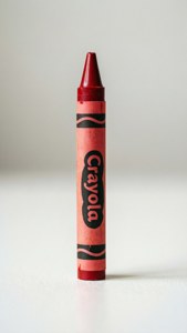 一支紅色 Crayola 蠟筆直立喺白色表面上。