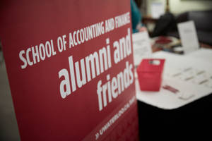 在校園聚會中，為School of Accounting and Finance的校友和朋友活動的紅色標誌。
