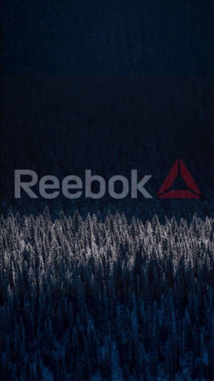 Reebok 標誌在黑暗冬季森林的雪松樹上方。